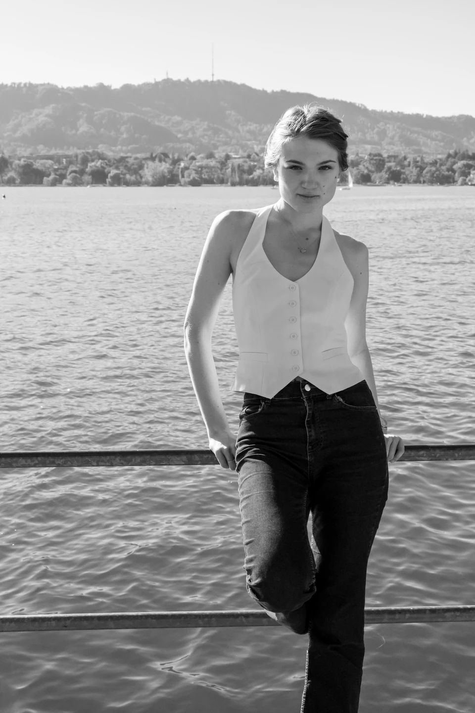 Monochrome portrait in a white top at the edge of the lake.
